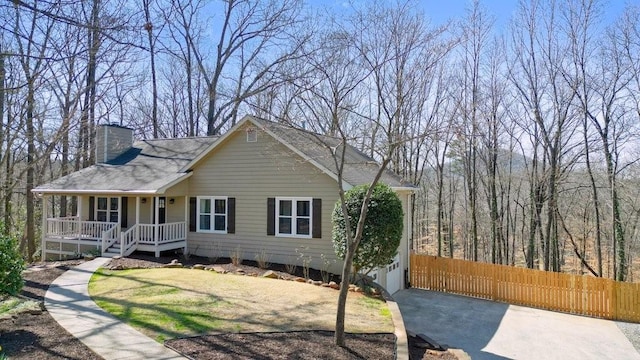 view of front of property with a porch, a chimney, and fence