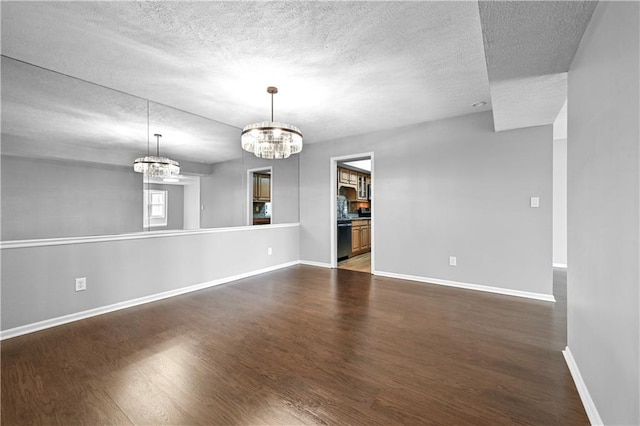 unfurnished room with dark hardwood / wood-style floors, a chandelier, and a textured ceiling