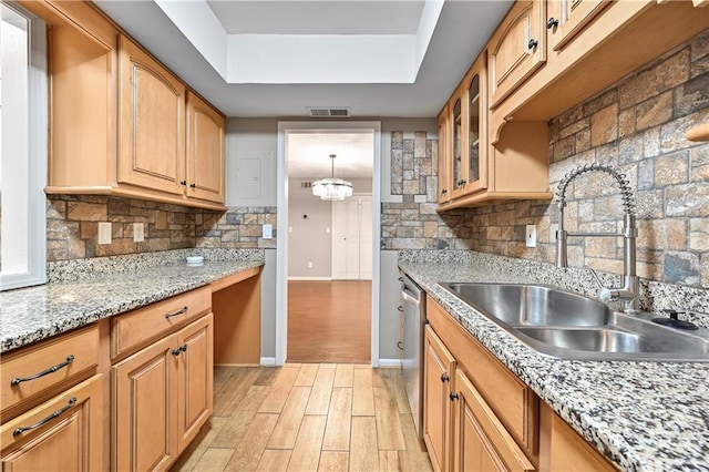 kitchen featuring tasteful backsplash, sink, light hardwood / wood-style floors, and a raised ceiling