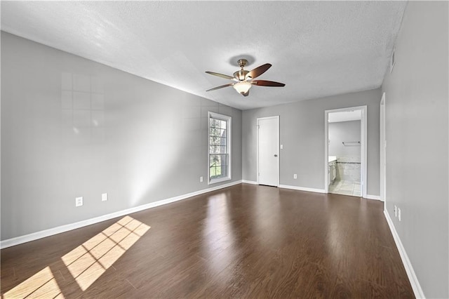 empty room featuring ceiling fan, dark hardwood / wood-style floors, and a textured ceiling