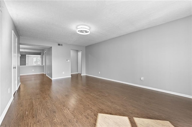 spare room with dark hardwood / wood-style flooring and a textured ceiling