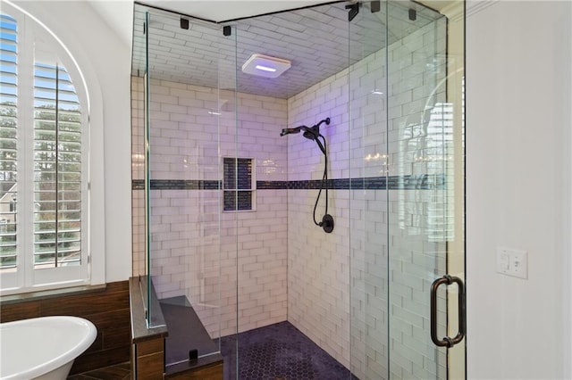 bathroom with a shower stall and a freestanding bath