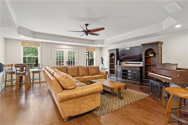 living area with french doors, wood finished floors, a raised ceiling, and visible vents