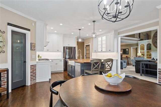 dining area featuring ornamental molding, dark wood-style flooring, an inviting chandelier, and recessed lighting