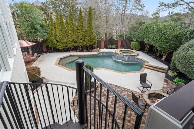 view of pool featuring a patio, a fenced backyard, and a pool with connected hot tub