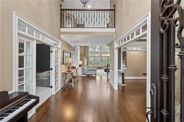 entryway featuring french doors, dark wood finished floors, a high ceiling, baseboards, and stairs