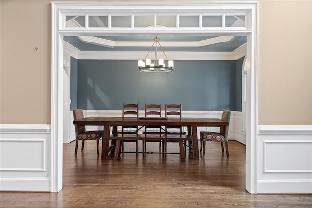 dining area with a chandelier, dark wood-style flooring, wainscoting, and crown molding