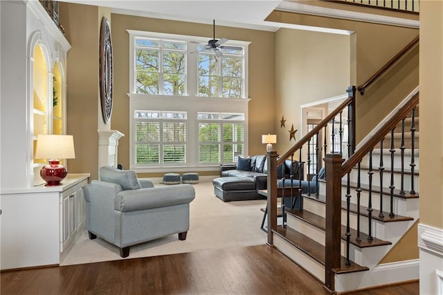 interior space featuring a high ceiling, stairway, wood finished floors, and a ceiling fan