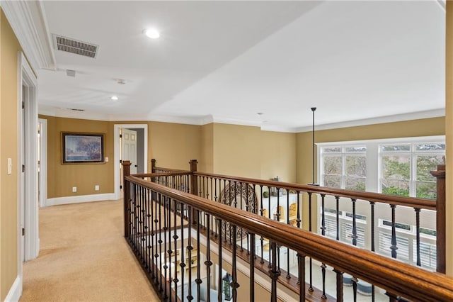 corridor with ornamental molding, visible vents, light carpet, and baseboards