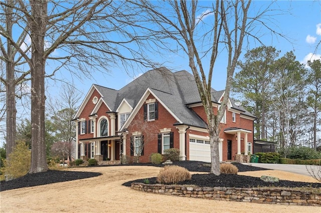 view of front of home featuring driveway, brick siding, and an attached garage