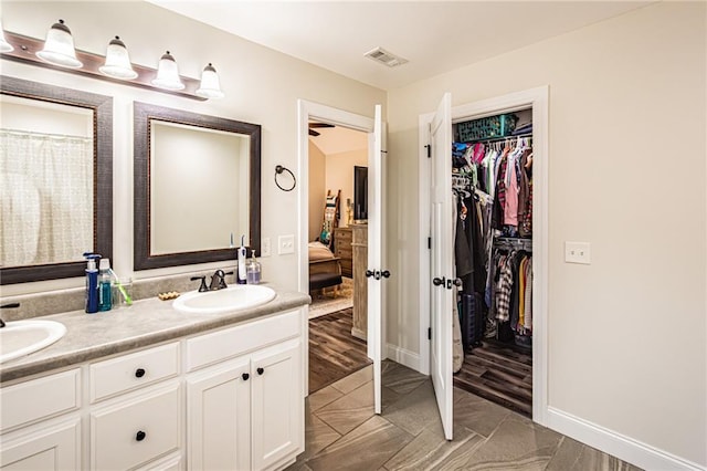 ensuite bathroom with visible vents, a sink, ensuite bathroom, and double vanity