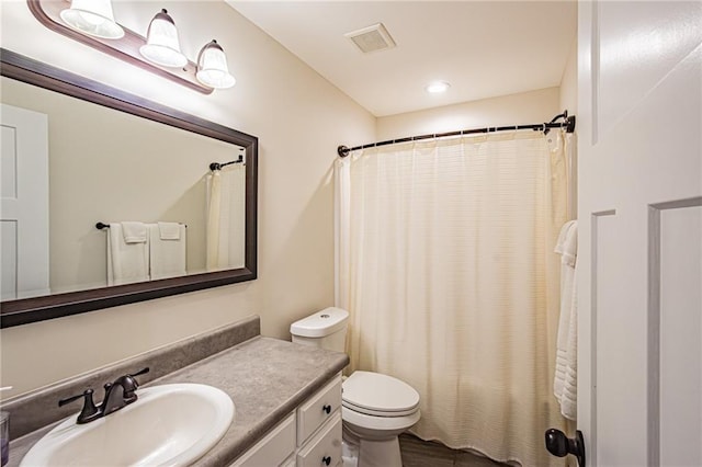 bathroom with toilet, a shower with shower curtain, vanity, and visible vents