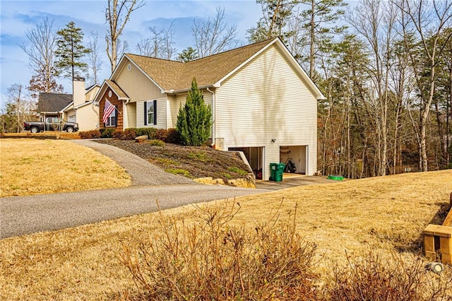 view of home's exterior featuring a garage and a lawn