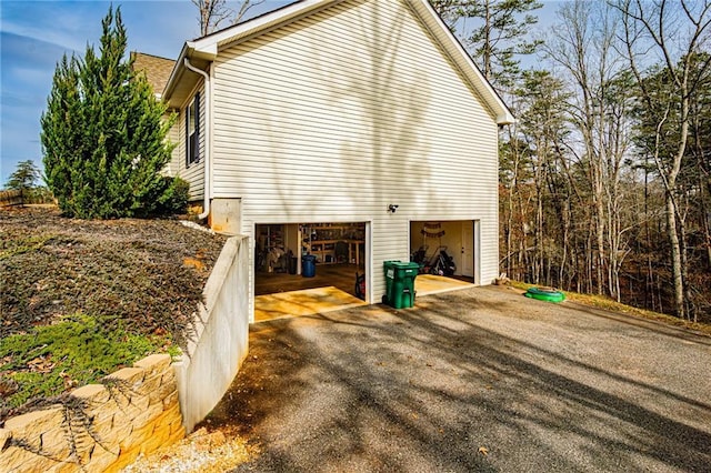 view of home's exterior featuring an attached garage and aphalt driveway