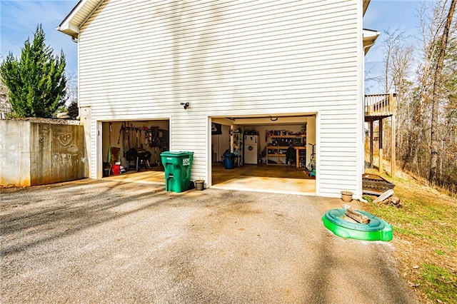 garage with water heater and aphalt driveway