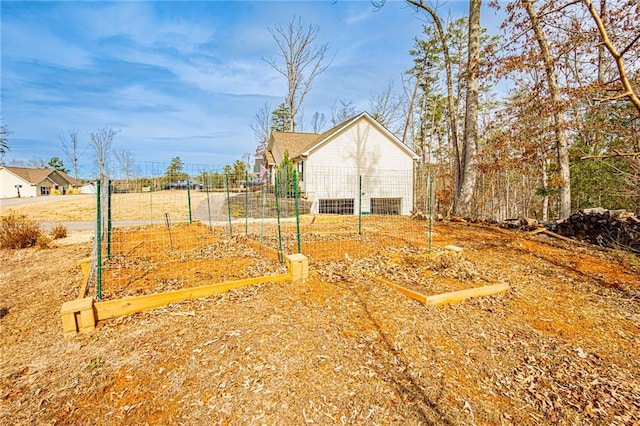 exterior space featuring a garden and fence