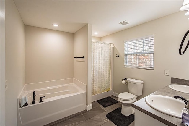 bathroom with double vanity, a garden tub, toilet, and a sink