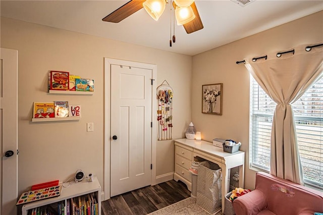 living area featuring ceiling fan, visible vents, dark wood finished floors, and a wealth of natural light