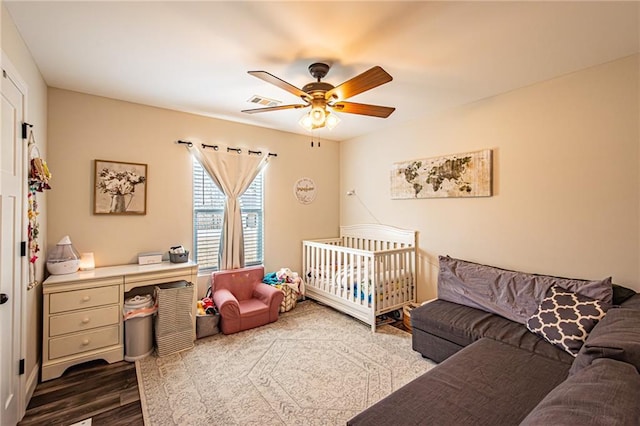 bedroom with visible vents, a ceiling fan, and wood finished floors