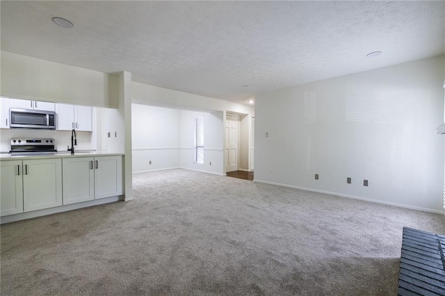 223 Tuxworth Cir, Decatur, GA 30033 - unfurnished living room with carpet floors, a textured ceiling, baseboards, and a sink