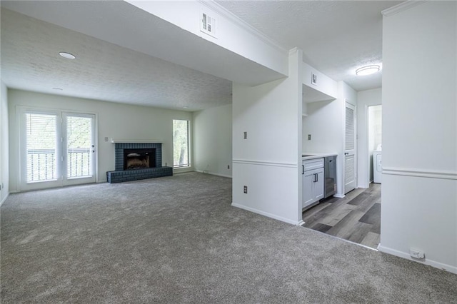 223 Tuxworth Cir, Decatur, GA 30033 - unfurnished living room featuring a brick fireplace, a textured ceiling, carpet, washer / dryer, and visible vents