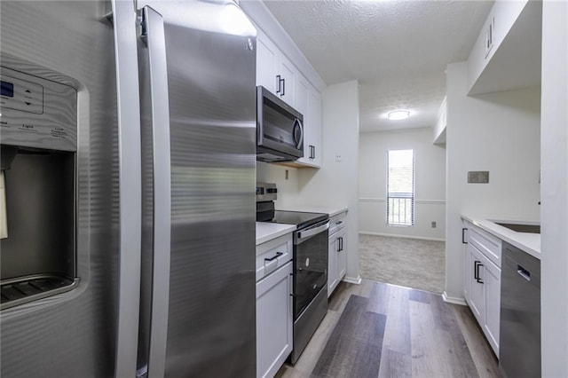 223 Tuxworth Cir, Decatur, GA 30033 - kitchen with light countertops, a textured ceiling, white cabinetry, dark wood finished floors, and appliances with stainless steel finishes
