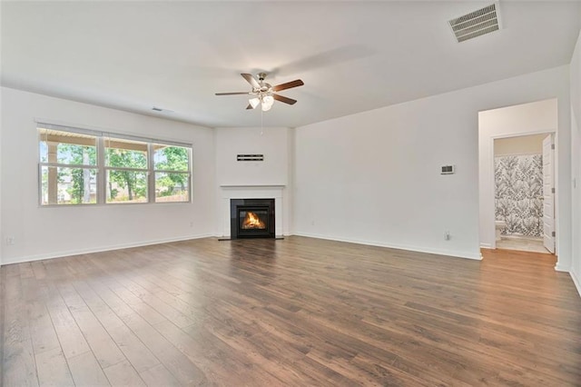 4117 Flat Rock Pt, Stonecrest, GA 30038 - unfurnished living room with ceiling fan, wood finished floors, a glass covered fireplace, and baseboards