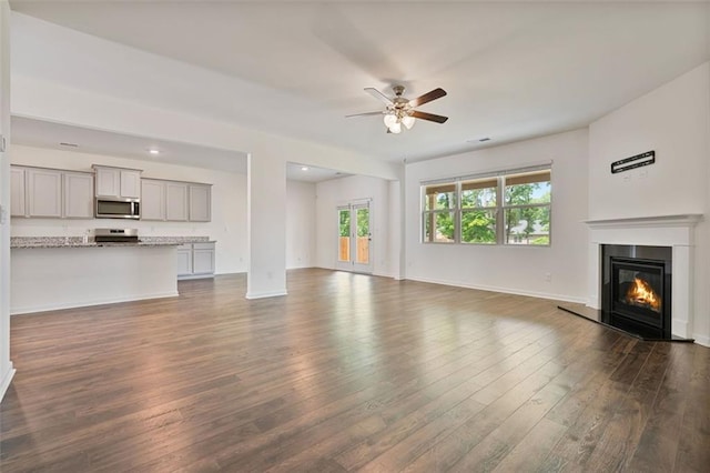 4117 Flat Rock Pt, Stonecrest, GA 30038 - unfurnished living room featuring dark wood-type flooring, ceiling fan, a glass covered fireplace, and baseboards