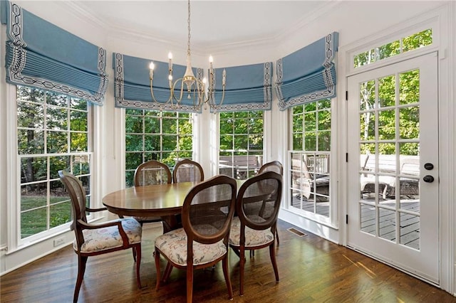 sunroom / solarium featuring a healthy amount of sunlight and a chandelier