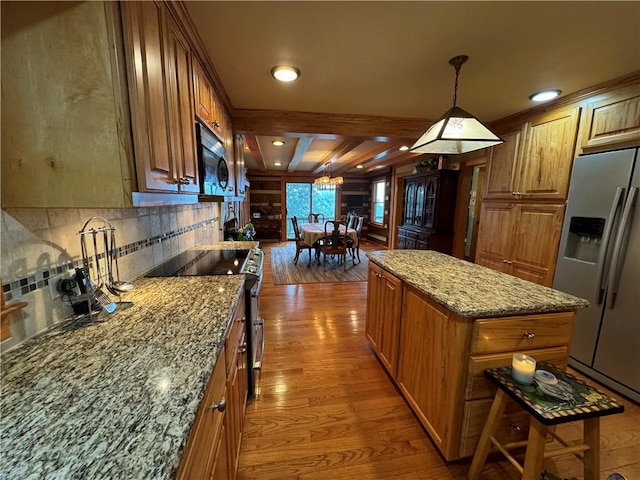 kitchen featuring pendant lighting, beamed ceiling, a kitchen island, appliances with stainless steel finishes, and hardwood / wood-style floors