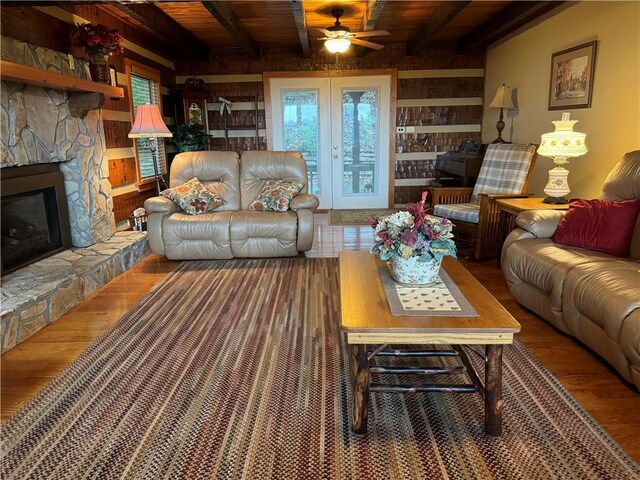 living room featuring wood-type flooring, beamed ceiling, wooden ceiling, and a fireplace