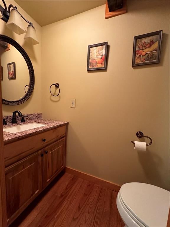 bathroom featuring hardwood / wood-style flooring, vanity, and toilet