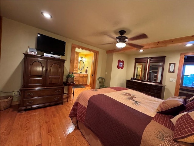 bedroom featuring ceiling fan, light hardwood / wood-style flooring, and connected bathroom