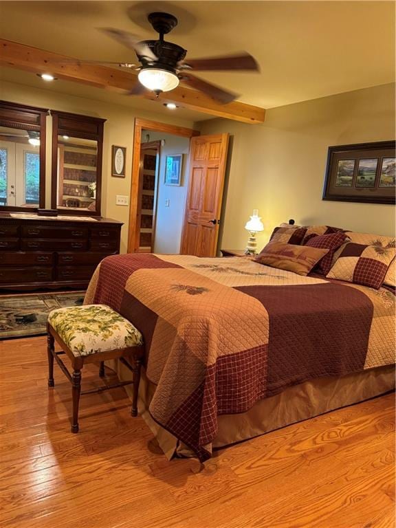 bedroom with light hardwood / wood-style floors, ceiling fan, and french doors