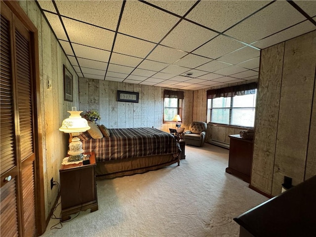 bedroom featuring carpet floors, a drop ceiling, and a closet