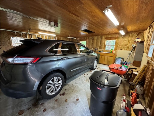 garage featuring a garage door opener and wooden ceiling