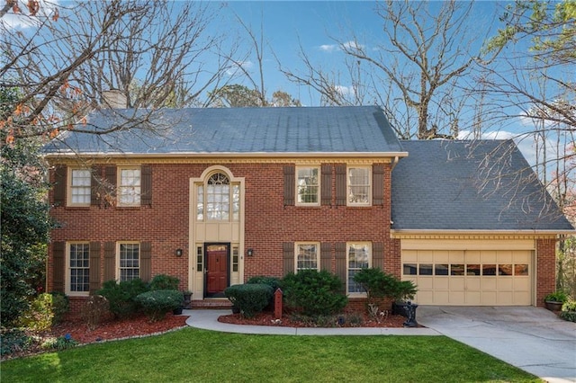 view of front of property featuring a front yard, an attached garage, brick siding, and driveway