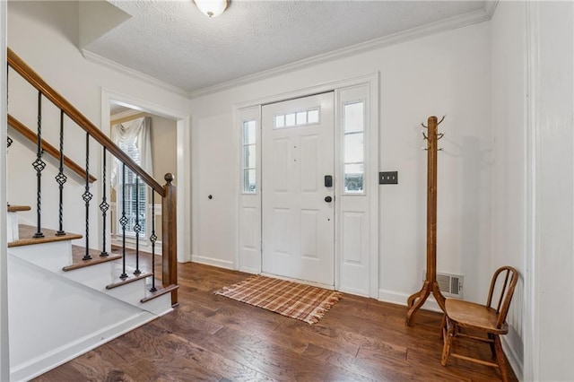 entryway with visible vents, a textured ceiling, wood finished floors, crown molding, and stairs