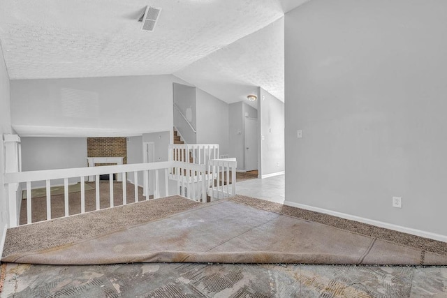 5338 Timor Trl, Lithonia, GA 30038 - unfurnished room with stairs, a textured ceiling, lofted ceiling, baseboards, and a fireplace