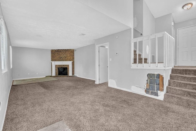 5338 Timor Trl, Lithonia, GA 30038 - unfurnished living room with carpet, baseboards, stairway, a brick fireplace, and a textured ceiling