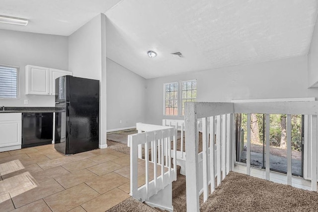 5338 Timor Trl, Lithonia, GA 30038 - kitchen featuring black appliances, lofted ceiling, dark countertops, white cabinetry, and light tile patterned flooring