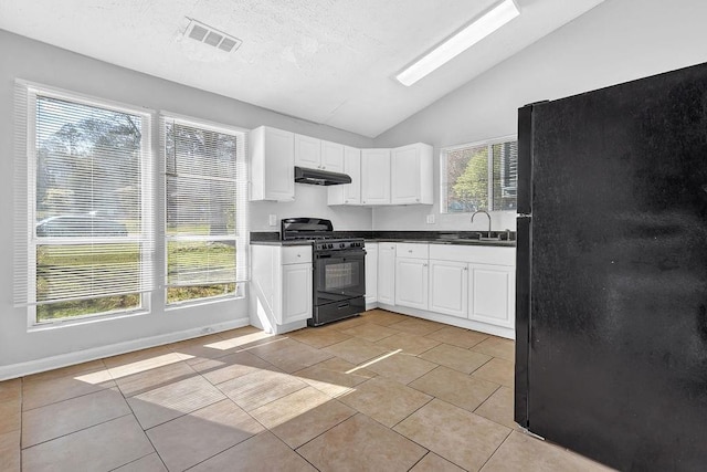 5338 Timor Trl, Lithonia, GA 30038 - kitchen featuring black appliances, under cabinet range hood, vaulted ceiling, a sink, and white cabinets
