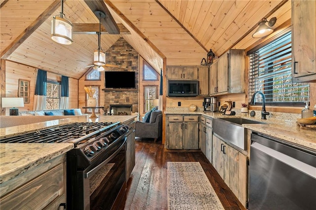 kitchen with wood walls, black range with gas stovetop, open floor plan, and dishwasher