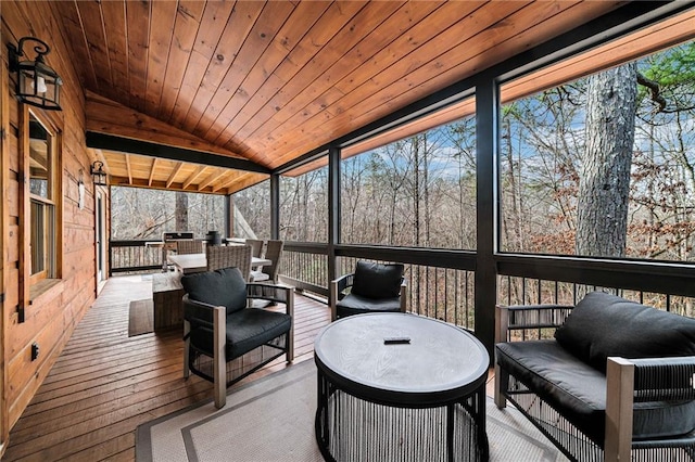 sunroom featuring lofted ceiling, wooden ceiling, and a wealth of natural light