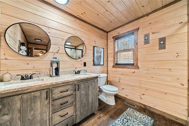 full bath featuring toilet, wood ceiling, visible vents, and a sink