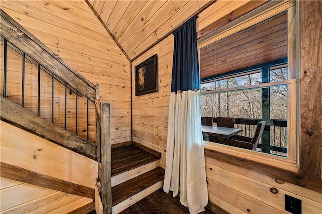 stairs featuring lofted ceiling, wood ceiling, wood walls, and wood finished floors