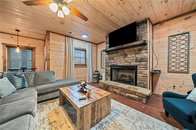 living room with wooden ceiling, visible vents, a fireplace, and wooden walls