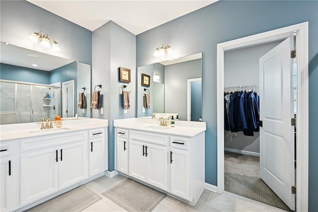 215 Dragonfly Way, Winder, GA 30680 - bathroom with a shower stall, two vanities, a walk in closet, baseboards, and tile patterned floors