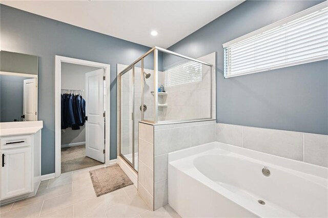 215 Dragonfly Way, Winder, GA 30680 - bathroom with a shower stall, two vanities, a walk in closet, baseboards, and tile patterned floors