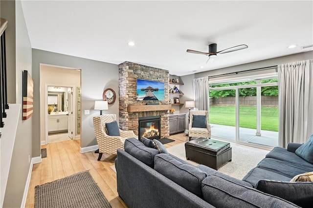 215 Dragonfly Way, Winder, GA 30680 - living area with a stone fireplace, light wood finished floors, ceiling fan, baseboards, and recessed lighting